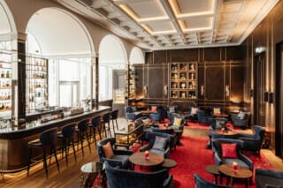 Hotel Atlantic Elegante Bar mit stilvollen Sitzgelegenheiten und einer beeindruckenden Getränkewand.
