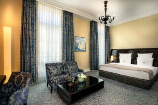 Elegant hotel room with a view of the lake, stylish decor and modern amenities.