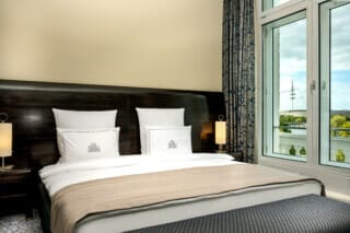 Modernes Hotelzimmer mit Blick auf den Fernsehturm, eleganter Einrichtung und gemütlichem Bett.