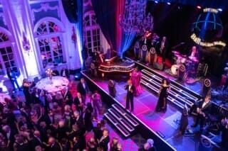 Elegant ball event with live music, dancers and festively dressed guests.