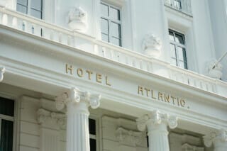 Fassade des Hotel Atlantic mit goldener Schrift und eleganten Säulen im klassischen Stil.
