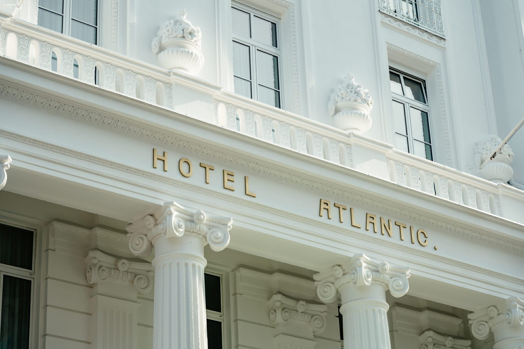 Hotel Atlantic Fassade des Hotel Atlantic mit goldener Schrift und eleganten Säulen im klassischen Stil.