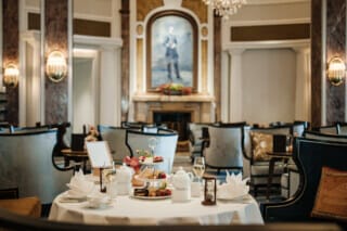 Elegant gedeckter Tisch im Restaurant mit Tee, Gebäck und stilvollem Ambiente.