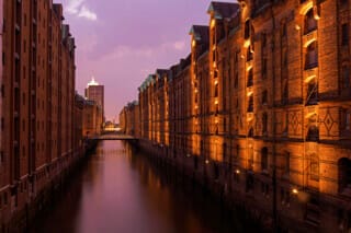 Abendliche Beleuchtung der historischen Speicherstadt in Hamburg am Wasser.