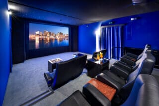 Home cinema with blue walls, comfortable seats and a large screen for film evenings.