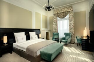 Elegantes Hotelzimmer mit Doppelbett, gemütlichen Sesseln und stilvollem Dekor.