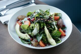 Hotel Atlantic Bunter Salat mit frischem Gemüse, Granatapfelkernen und Nüssen in einer Schüssel.