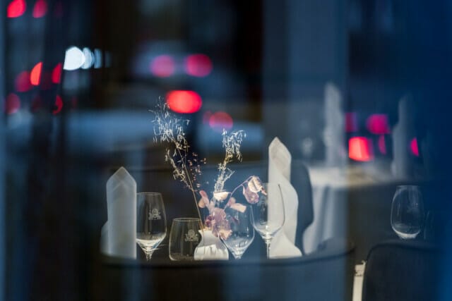 Elegant gedeckter Tisch mit Gläsern und dekorativen Blumen in einem Restaurant.