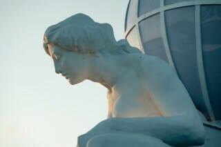 Hotel Atlantic Skulptur einer nachdenklichen Frau mit globusförmigem Element im Hintergrund.