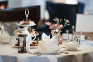 Elegantly laid table with tea, biscuits and decorative flowers in a restaurant.