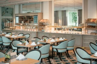 Elegantes Restaurant mit Buffet, modernen Tischen und stilvollen Stühlen für ein Frühstückserlebnis.
