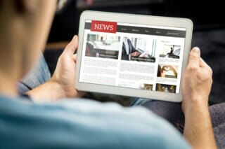 Hotel Atlantic Person reads news on a tablet, focussing on different topics.