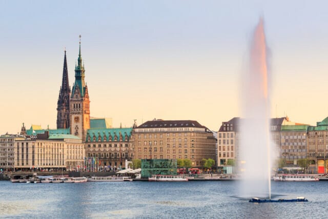 Hamburger Rathaus und Binnenalsterbrunnen bei Sonnenuntergang, Hamburg, Deutschland.