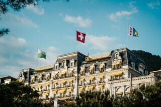 Grand Hotel Schweiz mit Flaggen und historischen Fassaden im malerischen Landschaftshintergrund.