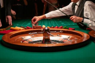 Ein Spieler platziert seine Jetons am Roulettetisch in einem eleganten Casino.