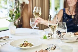 Elegantes Essen mit Wein und Wasser in einem stilvollen Restaurantambiente.