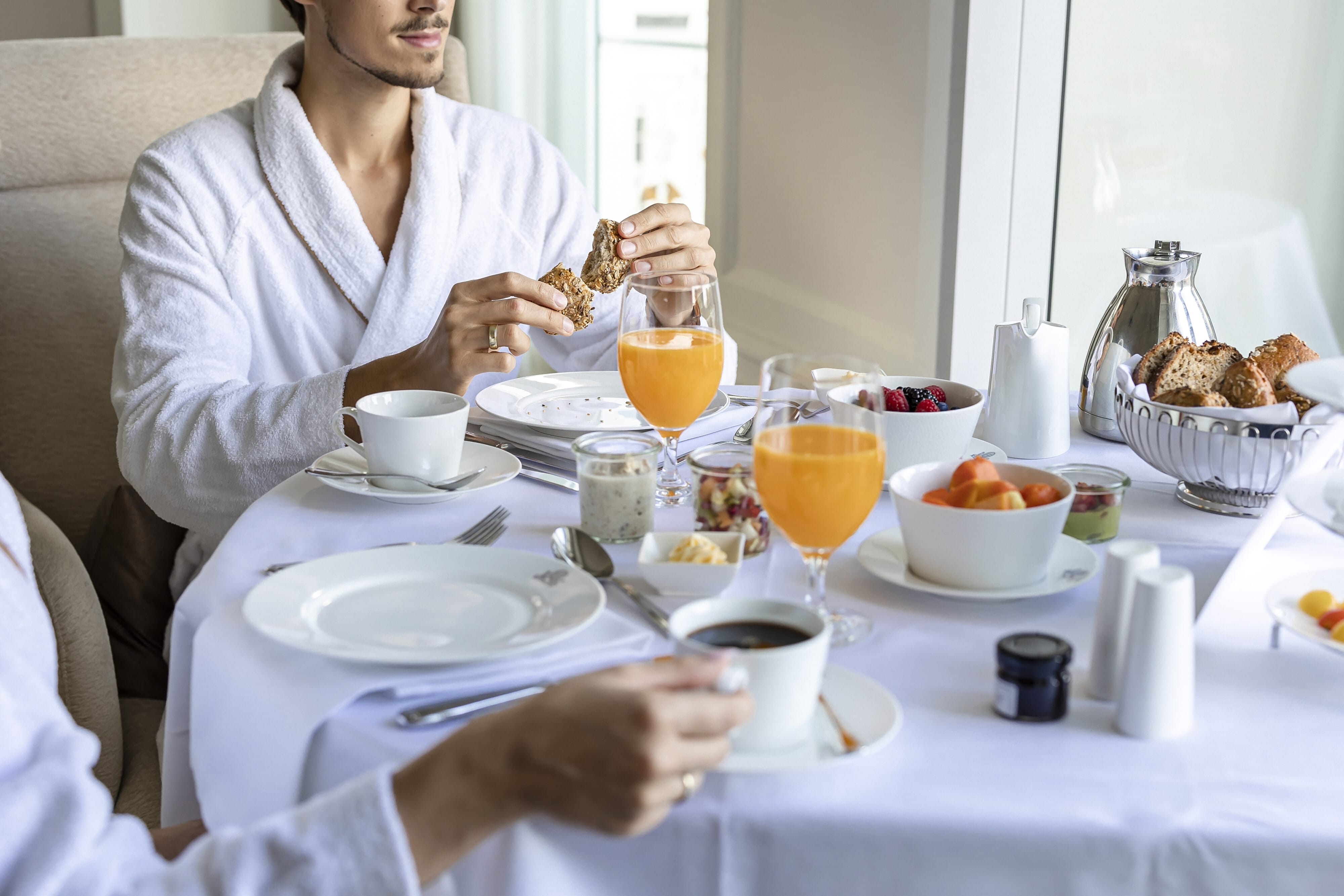 Hotel Atlantic Frühstückstisch mit frischen Früchten, Säften und Kaffee, serviert im eleganten Ambiente.