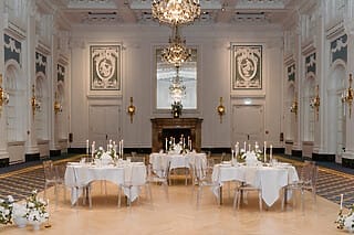 Elegant dekorierter Festsaal mit Tischen, Kerzen und Blumenarrangements für Veranstaltungen.