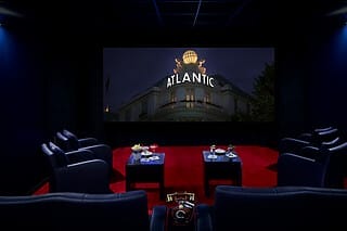 Luxuriöses Heimkino mit bequemen Sesseln, Snacks und der Atlantic-Fassade im Hintergrund.