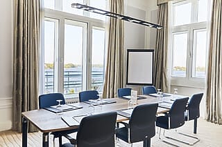 Moderne Konferenzräume mit Blick auf den See, ausgestattet mit Tischen und Stühlen.