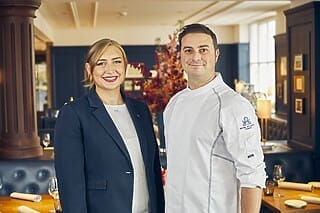 Portrait eines Teams aus Hotel und Restaurant mit lächelnden Fachleuten im eleganten Ambiente.